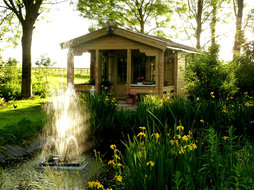 chalet in de tuin voor de vijver met fontein