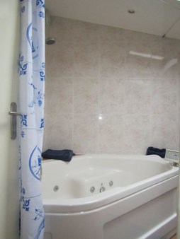 Luxe badkamer met tweepersoons jacuzzi.